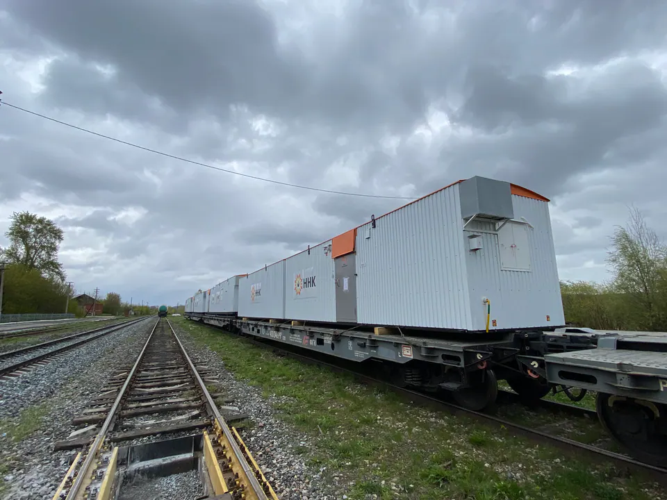 Белые модульные блоки на железнодорожных платформах вдоль путей